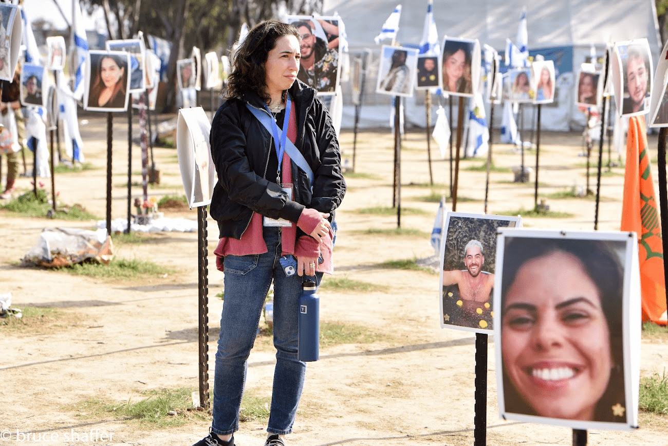 Melissa Garlick stands at the Nova Music Festival Site, as sounds of war can be heard in the background.